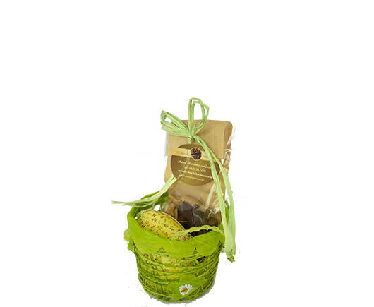 Panier de Pâques printanier orné de fleurs contenant un oeuf en carton décor fleuri garni de petits oeufs pralinés et un sachet de fritures.